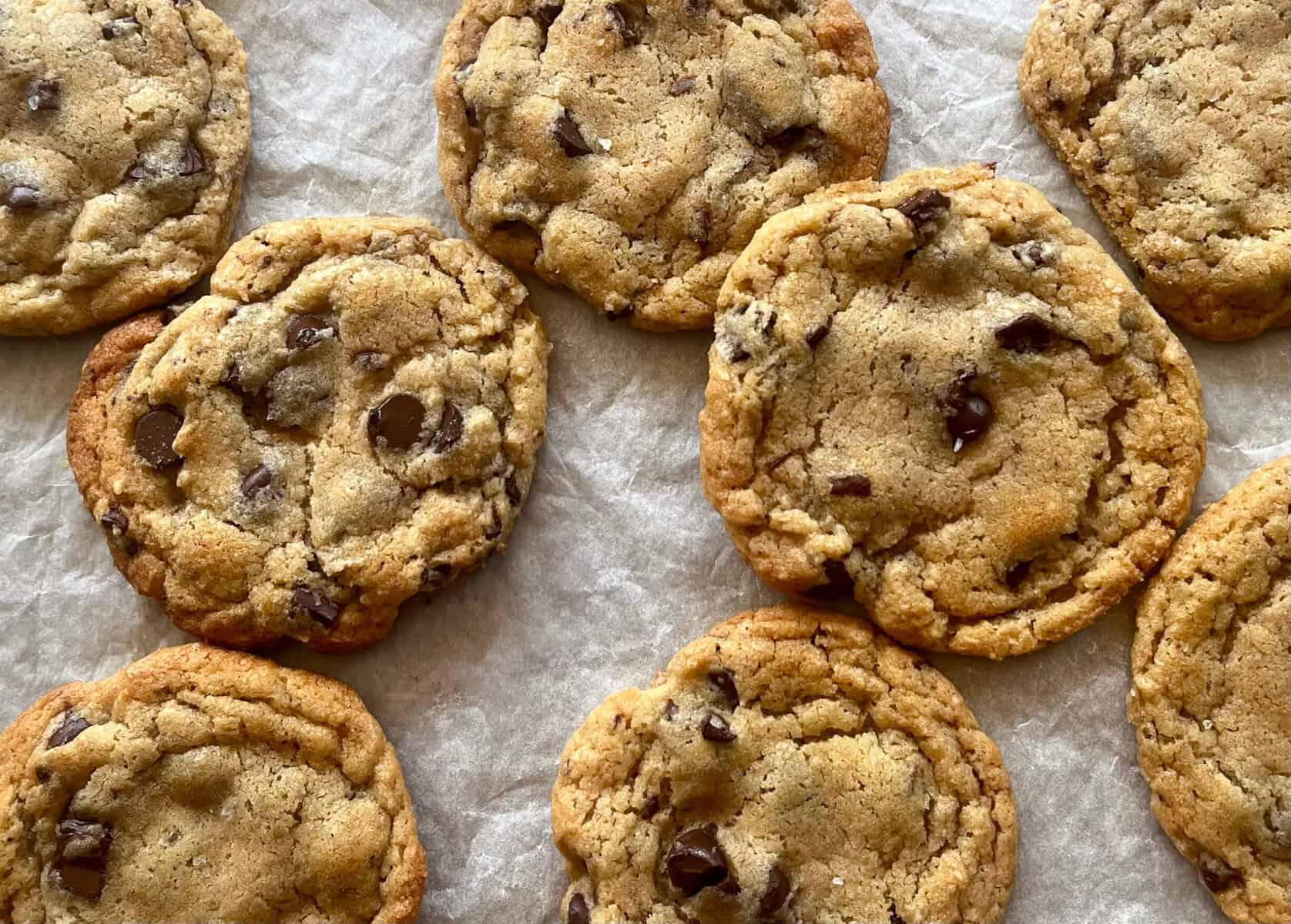 lightly browned chocolate chip cookies on parchment paper