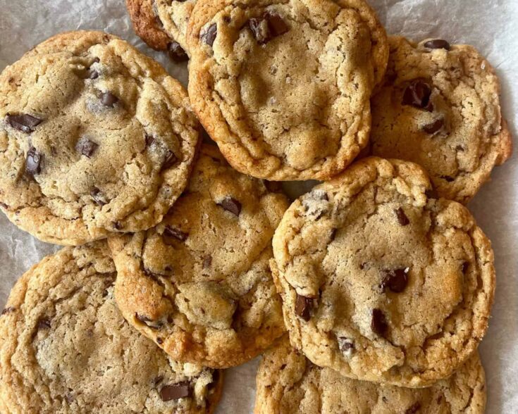 A pile of homemade chocolate chip cookies with lightly browned edges